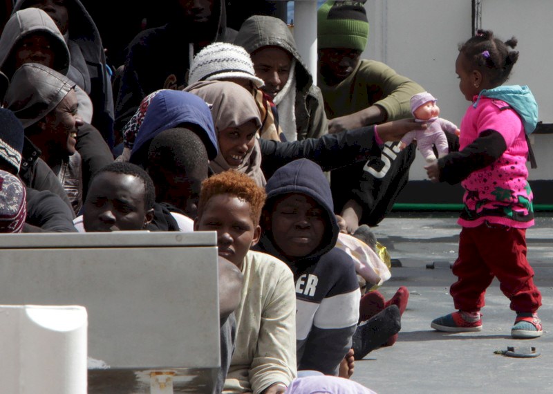 Personas migrantes y refugiadas esperan desembarcar en el puerto de Messina tras una operación de salvamento en el mar del guardacostas italiano...