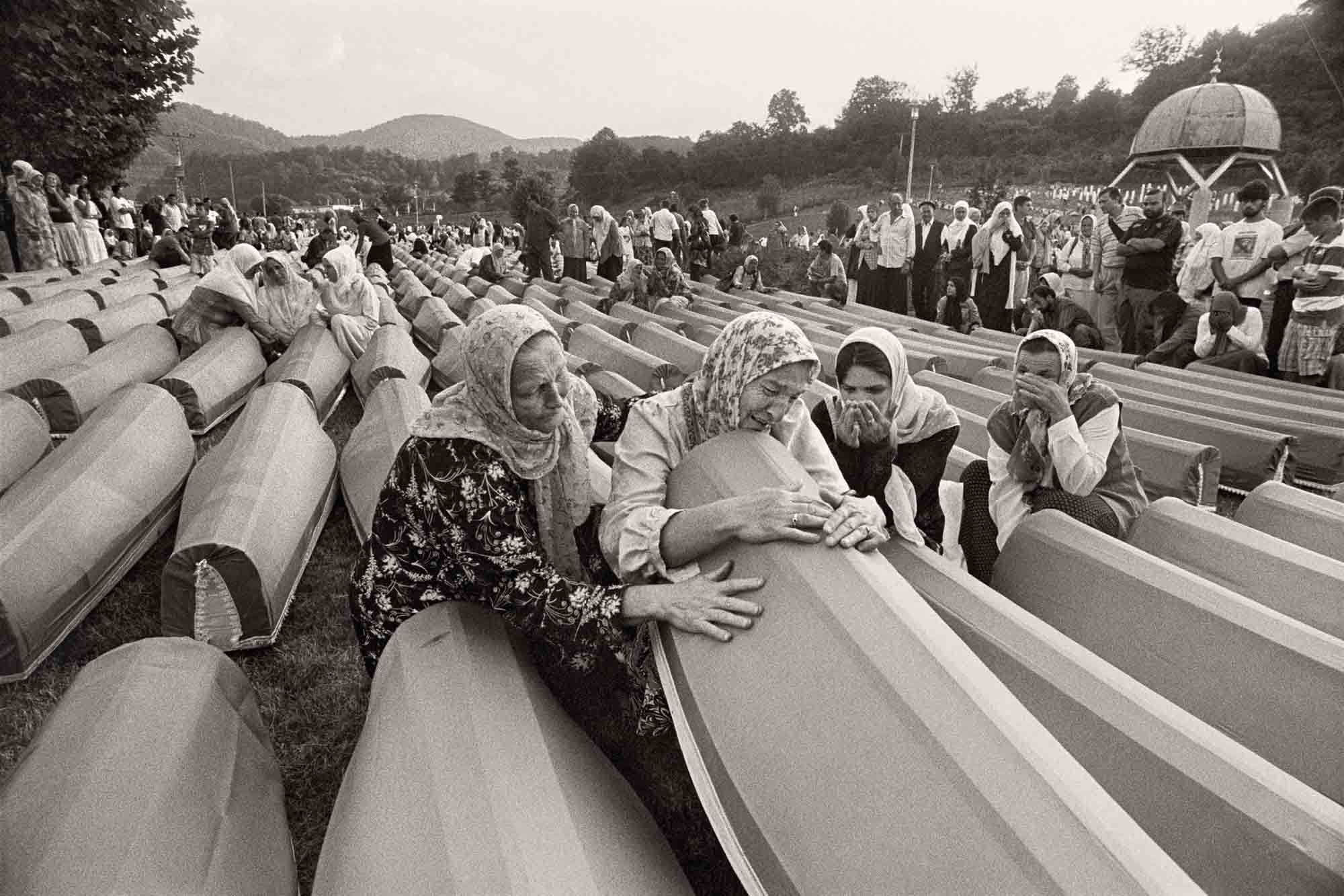 Varias madres y esposas de víctimas lloran antes del inicio de la ceremonia fúnebre que se realiza cada 11 de julio desde 2003.