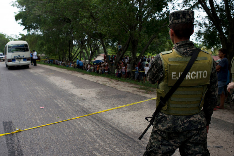 Un soldado vigila la escena de un crimen cometido en Choloma, Honduras, donde dos personas fueron asesinadas. 