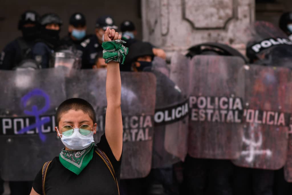 Una mujer levanta el puño delante de la policia