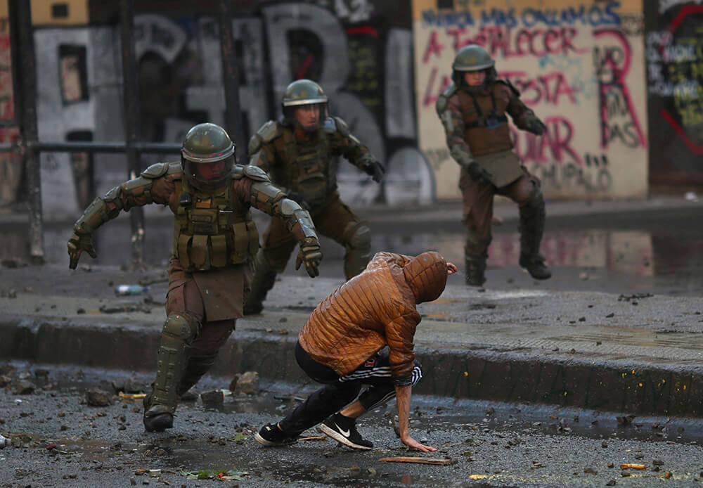 Un policía antidisturbios persigue a un manifestante durante las protestas contra el gobierno de Chile, el 14 de diciembre de 2019