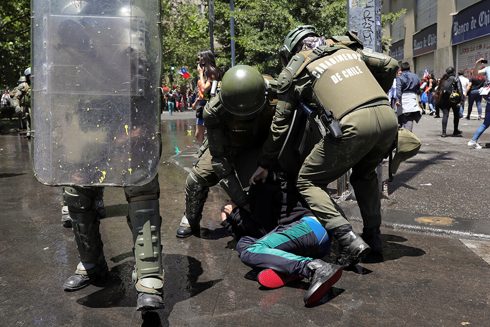 Un manifestante es detenido por la policía antidisturbios durante una protesta contra el gobierno de Chile, 26 de noviembre de 2019. 