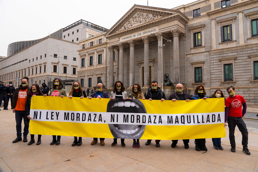 Representantes de las entidades detrás de una pancarta que dice: ni ley mordaza ni mordaza maquillada